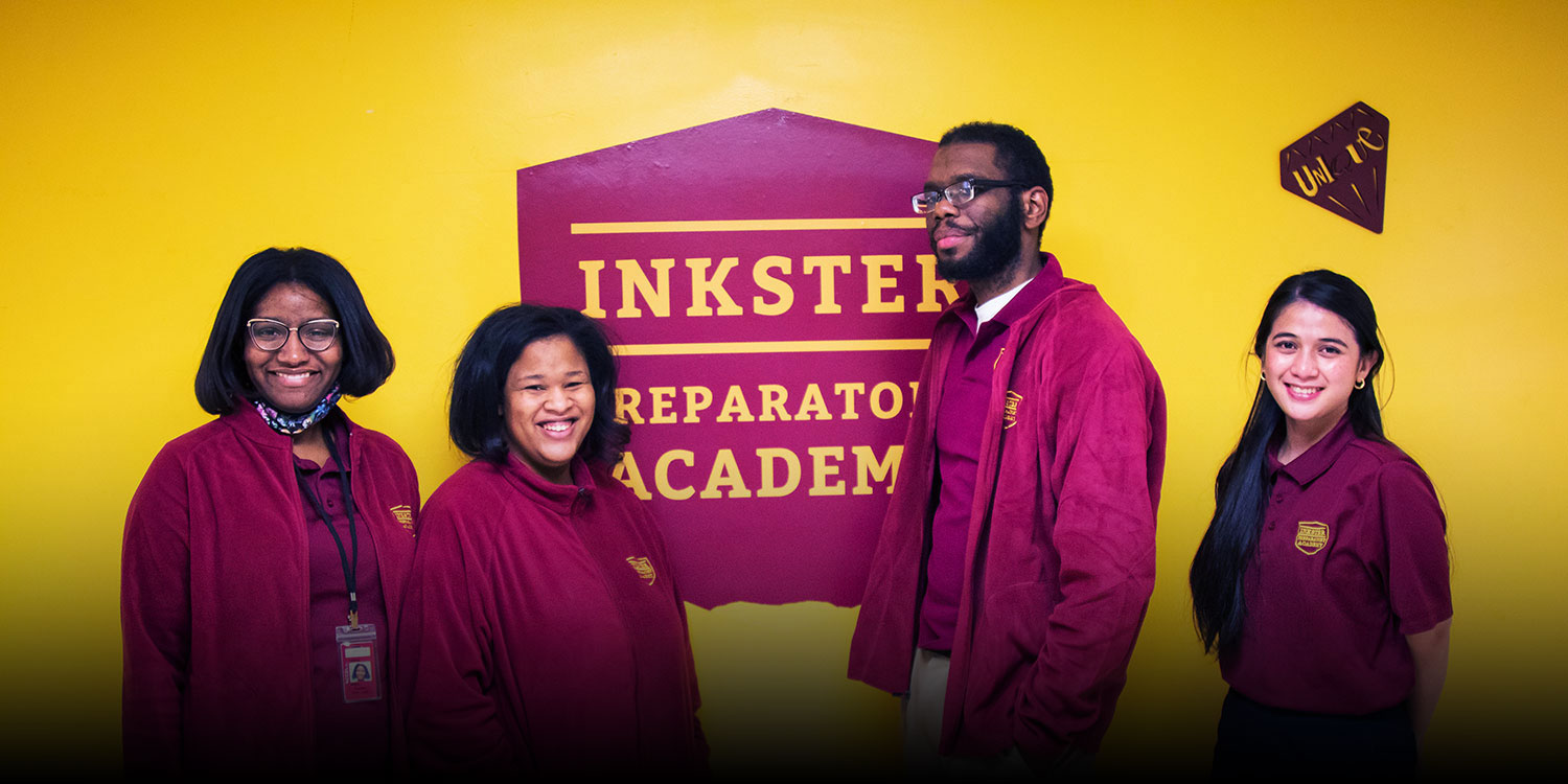 Inkster Prep staff standing in front of hallway sign.